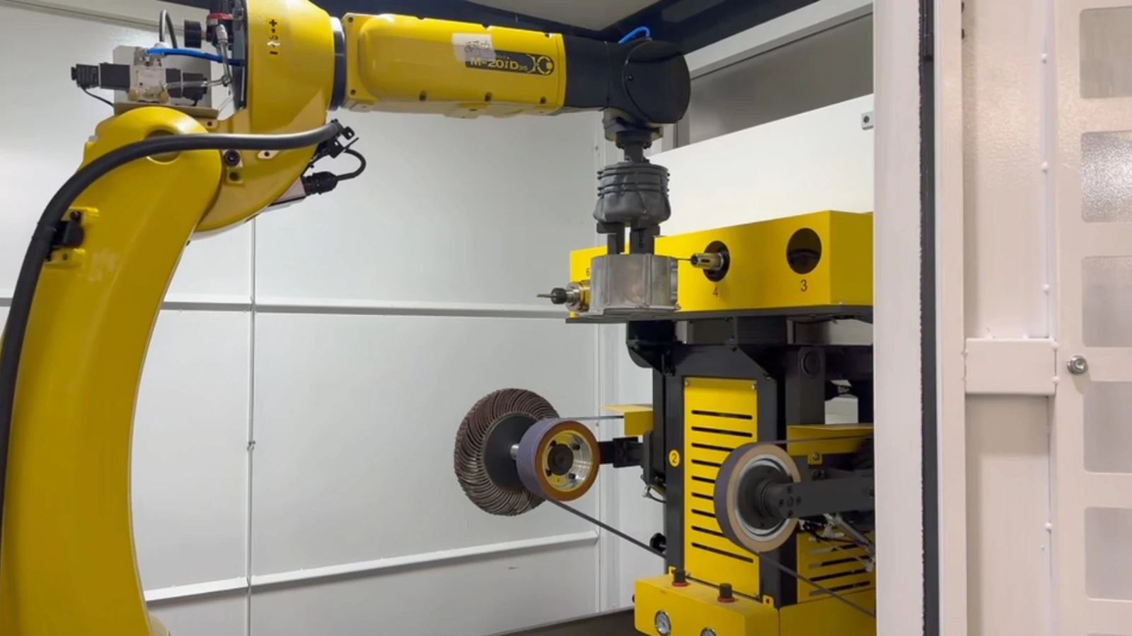 Robotic deburring cell processing an aluminum die casting