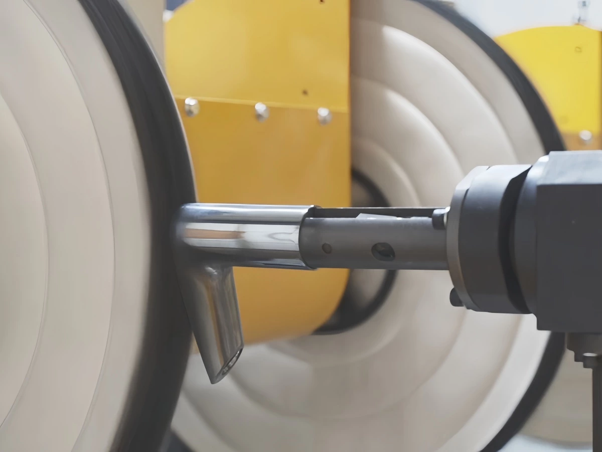 Cloth wheel contacting the outer surface of a stainless steel lever handle